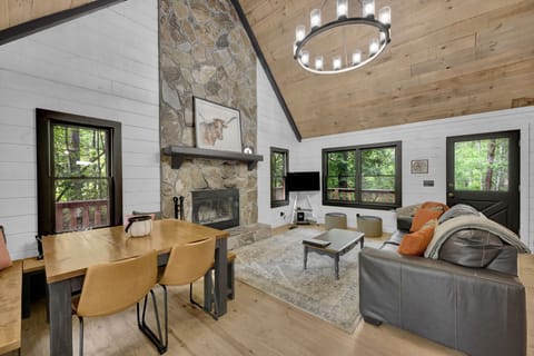 Comfortable main living room with dining, Roku TV, fireplace, and leafy views.