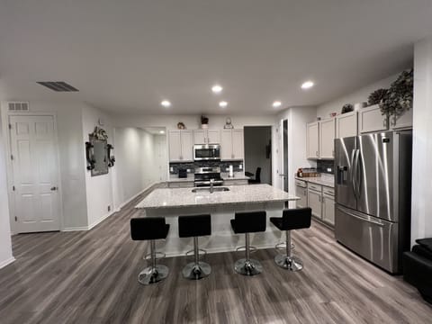 Kitchen with granite counter and barstools.