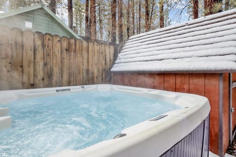 Private outdoor hot tub, surrounded by tall pines, perfect for relaxing under the trees after a day of adventure—enjoy peaceful forest views, fresh air, and a truly rejuvenating stay.