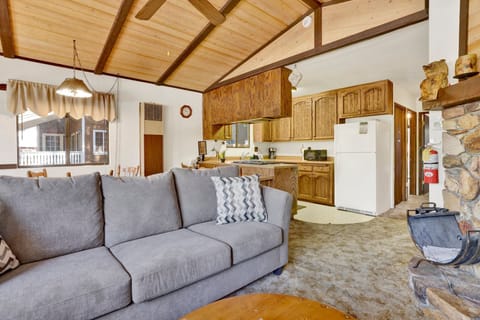 Cozy mountain living room with a stone fireplace, comfy seating, and smart TV—perfect for relaxing evenings, movie nights, and warm cabin vibes after outdoor adventures.