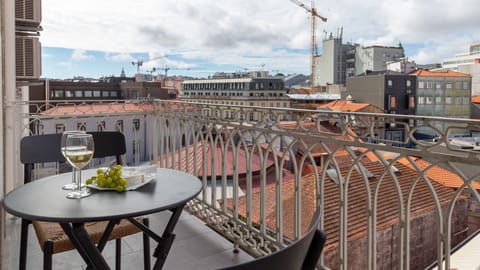 Savor a glass of local wine on your charming balcony, admiring the unique city rooftops and the distant urban landscape under a dynamic sky. This private outdoor space is ideal for unwinding and creating memorable vacation moments.