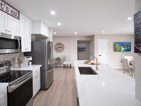 Open concept kitchen with dining room, large island, designated workspace, and fully stocked with all basic cooking essentials