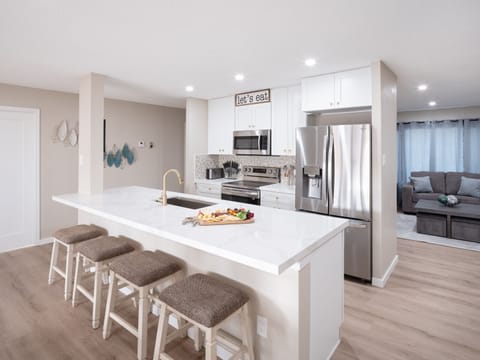 Open concept kitchen with dining room, large island, designated workspace, and fully stocked with all basic cooking essentials