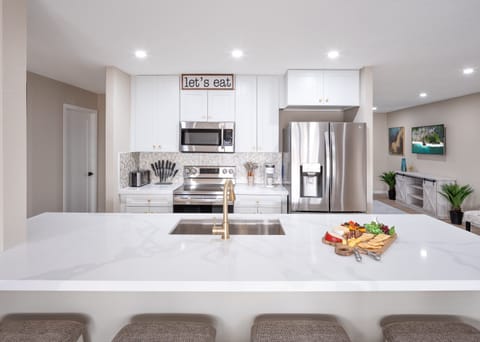 Open concept kitchen with dining room, large island, designated workspace, and fully stocked with all basic cooking essentials