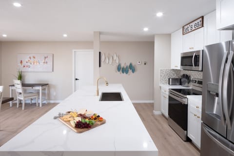 Open concept kitchen with dining room, large island, designated workspace, and fully stocked with all basic cooking essentials