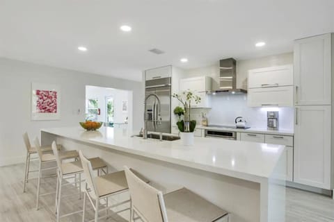 Indulge in our modern chef's kitchen, complete with a spacious island seating 5. Stainless steel appliances, including a double-door fridge and ice maker, set the stage for culinary excellence.