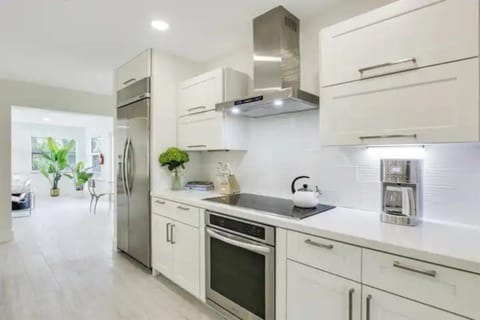 Indulge in our modern chef's kitchen, complete with a spacious island seating 5. Stainless steel appliances, including a double-door fridge and ice maker, set the stage for culinary excellence.