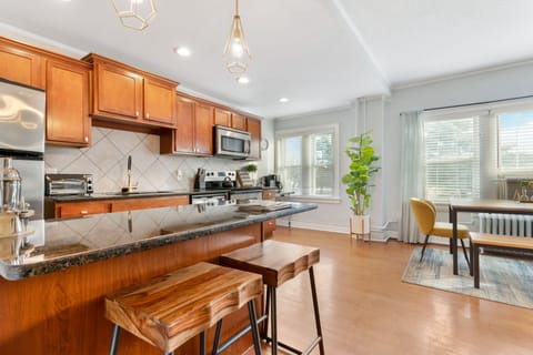 Spacious, fully equipped kitchen featuring granite countertops, stainless steel appliances, and an island with bar seating—perfect for cooking meals or gathering before heading out to the Plaza.