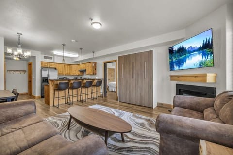 The view over the light-filled dining/living room where you will find a dining table, fireplace, pull-out sofa, a murphy bed and access to the private balcony.