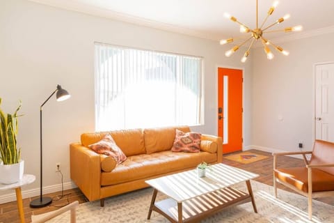 Spacious and stylish living room with leather couch and huge Roku TV