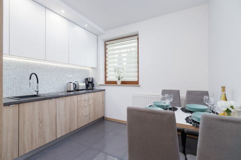 An alternate view of the kitchen highlighting ample countertop space, a small dining area, and modern finishes.






