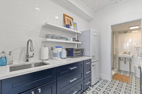 Large, fully stocked kitchenette with microwave, fridge, Keurig coffee maker, glasses, plates, and cutlery
