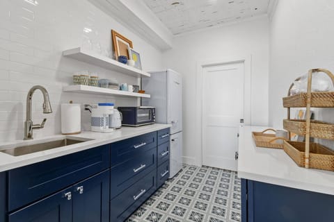 Large, fully stocked kitchenette with microwave, fridge, Keurig coffee maker, glasses, plates, and cutlery
