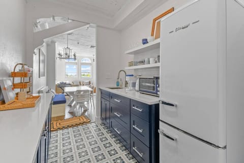 Large, fully stocked kitchenette with microwave, fridge, Keurig coffee maker, glasses, plates, and cutlery
