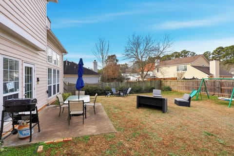 spacious backyard with patio seating, grill, and swing set-perfect for fam fun
