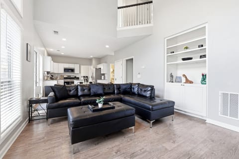 Spacious living room with high ceilings, Smart TV, and comfortable seating.