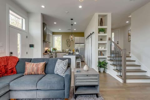 Relax in style: Our bright, open-concept living room features a custom designer sectional and 70” Smart TV.