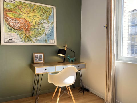 Séjour lumineux avec canapé, table à manger et kitchenette ouverte, T2 hypercentre Toulouse Saint-Aubin