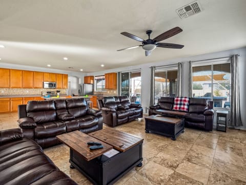 Ample seating with recliners and 86” tv in open concept room 