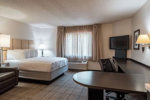 Unwind in a bright king room with workspace and TV.