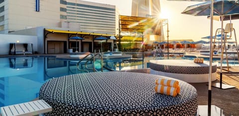 Dive into golden-hour relaxation with plush daybeds and calm water.