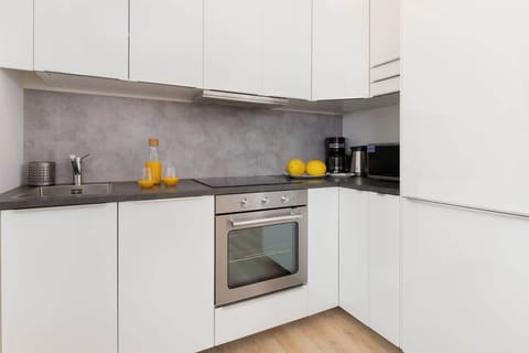 Fully equipped kitchenette with a fridge, freezer, oven, microwave, electric stovetop, kettle, dishwasher, coffee machine