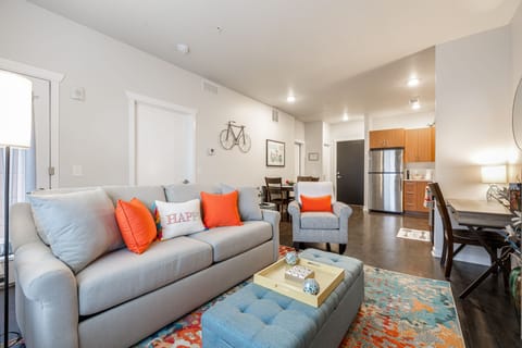 Open-concept living area w/ comfy sofa, bright accents & kitchen just steps away.