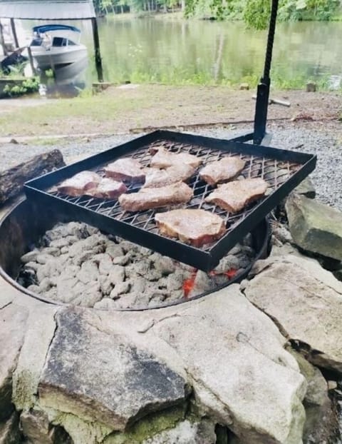 Grilling and fire pit by lake with swing and gliders