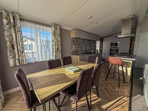 Sunlit dining area with modern kitchen and cozy seating