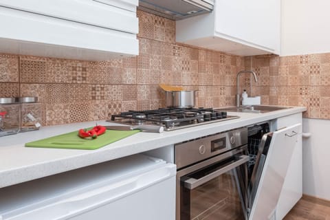 A close-up of the kitchen workspace with a cutting board and fresh vegetables, showcasing functionality.
