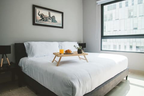 Master Bedroom - Find peace in the cozy and comfortable bedroom with a queen bed. Enjoy the serene view of the city and soothing neutral tones. Rest and recharge in this tranquil space.