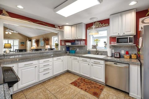 Spacious kitchen with white cabinets and built-in appliances