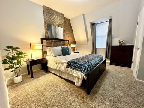 Bedroom 2 with dresser, desk, extra walk-in closet, and blackout curtains.