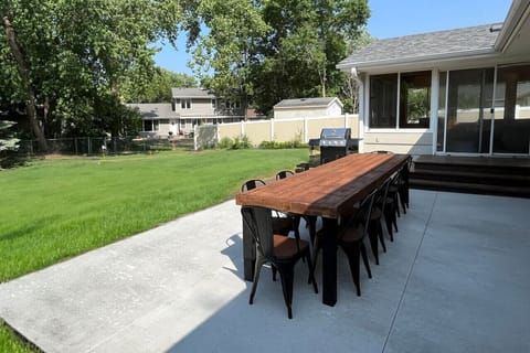 Rear patio with GAS GRILL and outdoor dining that seats 12. Spacious fenced in backyard with yard games, and private putting green!