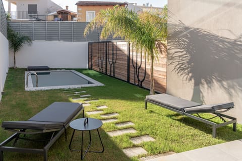 The pool area is equipped with 2 sun beds, a double day bed and lawn covered area