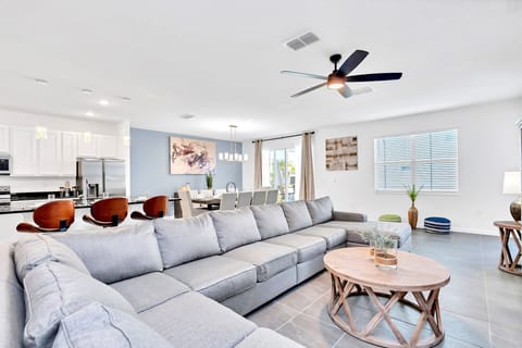 Expansive Open Living Area With A Plush Sectional Sofa Stylish Coffee Table And Seamless Access To Dining And Kitchen Spaces
