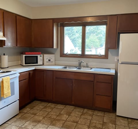 Fully-equipped kitchen with dishes, glassware, flatware, pots, pans, seasonings.