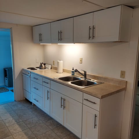 Kitchen with electric range, sink, and storage