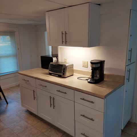 Kitchen bar area with toaster, microwave, and coffee maker