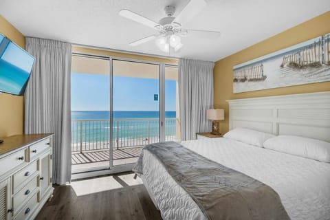 Master bedroom with balcony access, tv and a comfortable king-size bed