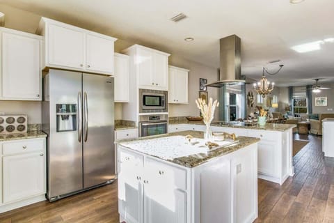 Fully equipped kitchen w/ island, Stainless steel refrigerator , and restaurant style fan