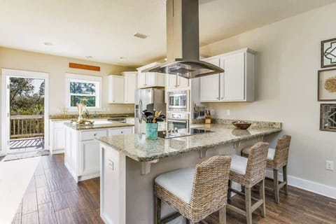 Fully equipped kitchen w/ island, barstools, and restaurant style fan