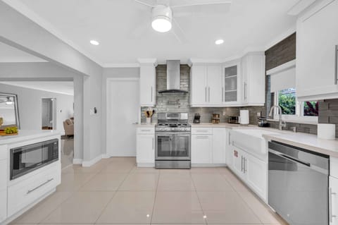 The large open kitchen is equipped with state of the art appliances for every gourmet chef. Extra counter space and a perfect view of the living room, dining room, and backyard oasis.