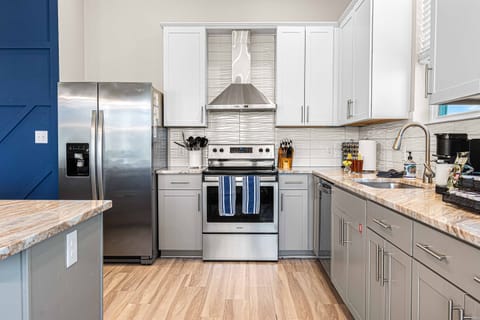 Fully equipped kitchen with stainless appliances and space for family cooking.