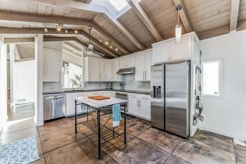 Kitchen view into the dining room with sky lights, and marble top kitchen island. 