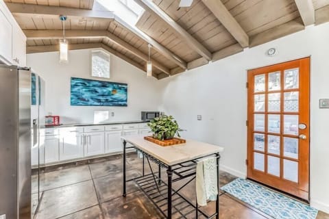 Back of kitchen area with a wall of cabinets, microwave, toaster oven, and Back Patio Door