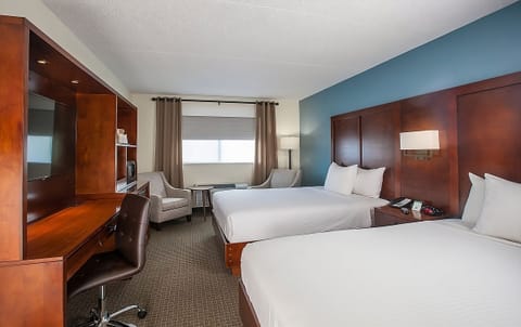 Unwind in a spacious double-queen room with cozy lounge seating.