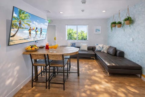 Stylish Open Living Space Featuring Leather Seating, Modern Kitchen, and Warm Wood Floors
