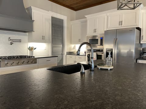 Kitchen with gas stove, pot filler, touch faucet.