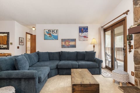 Cozy living room with plush sectional sofa and rustic charm, perfect for relaxing after mountain adventures.